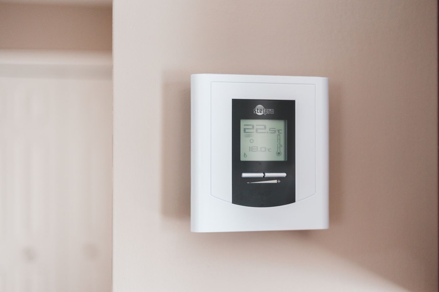 Digital wall thermostat controlling indoor temperature